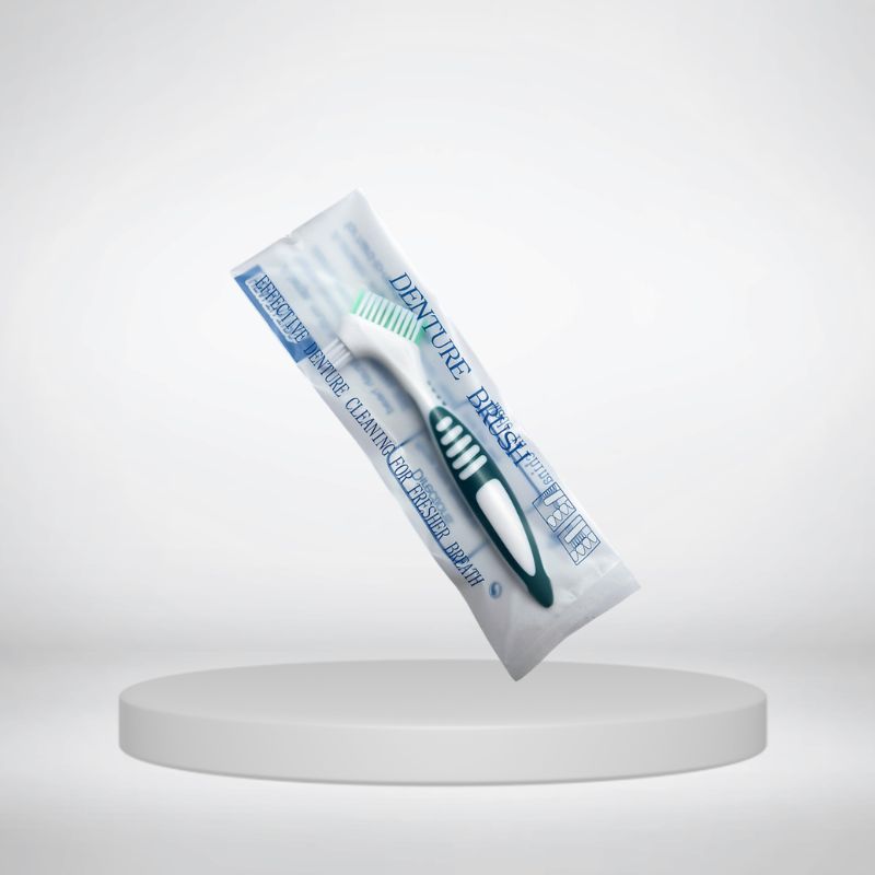 Compact denture toothbrush displayed against a plain background
