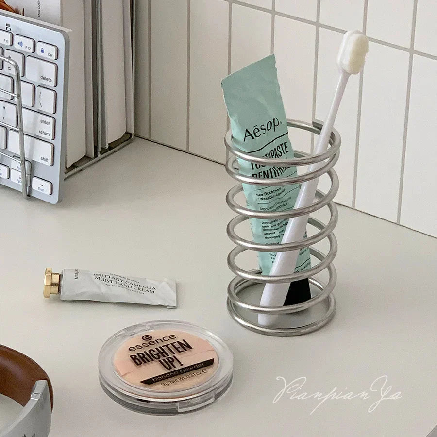 Metal toothbrush holder displayed on a bathroom countertop