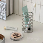 Metal toothbrush holder displayed on a bathroom countertop